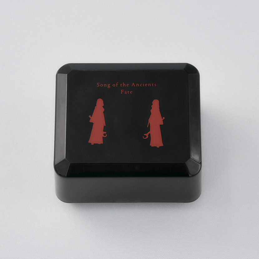 Black square music box with red silhouette figures and the words "Song of the Ancients Fate" printed on the lid.