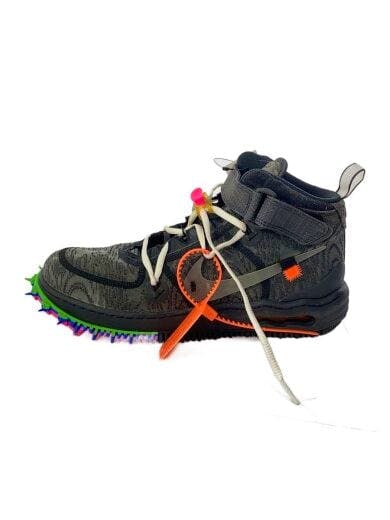 Side view of a black Air Force 1 Mid shoe with white laces, an orange zip tie tag, and a multicolored spiked sole on a white background.