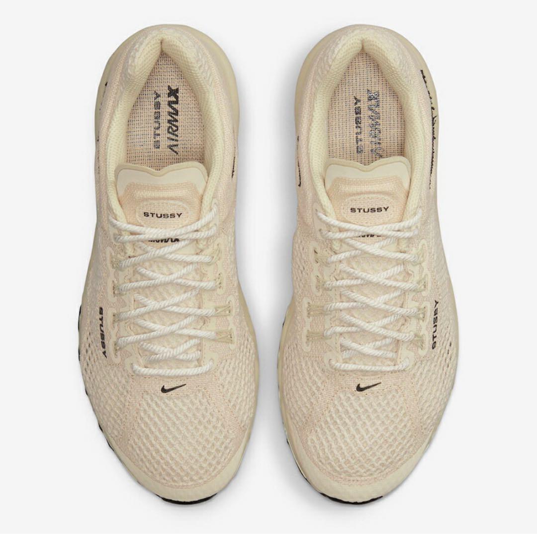 Top-down view of a pair of beige Nike Air Max 2013 x Stussy sports shoes on a white background.