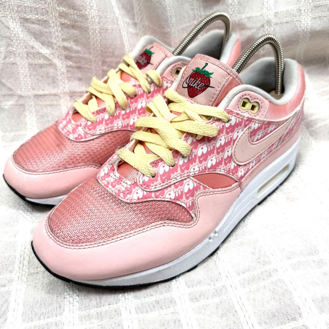 Pink NIKE Air Max "Strawberry" sneakers photographed from a front-side angle on a white fabric background.