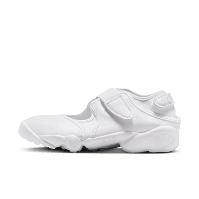 Side profile of a white Nike Air Rift sandal in synthetic leather on a black background.