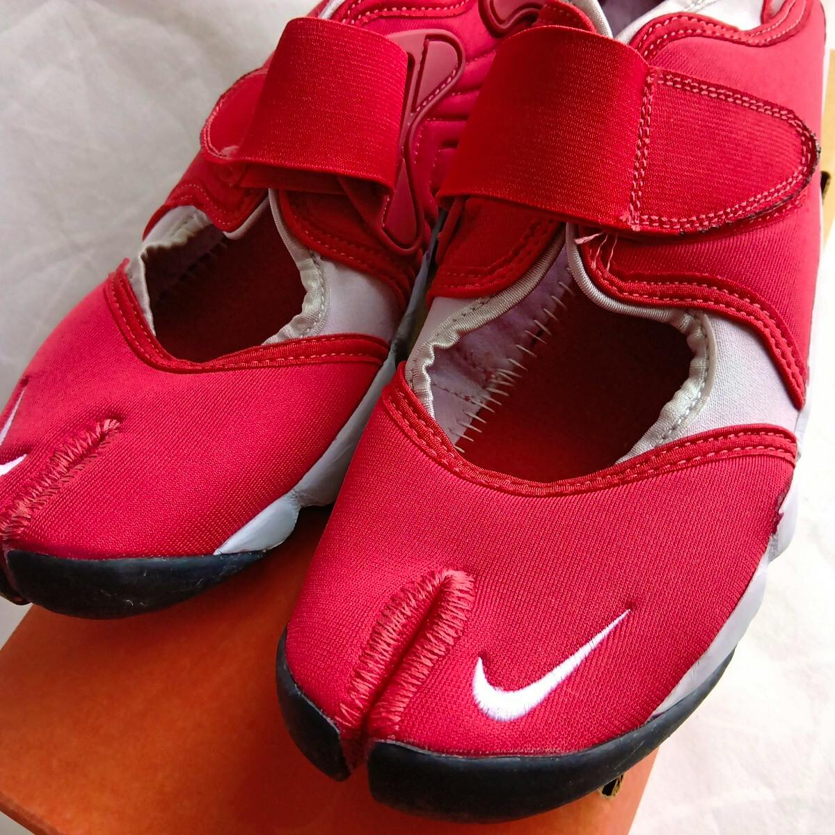 Close-up of a pair of varsity red Nike Air Rift shoes showing the split-toe and white Swoosh.