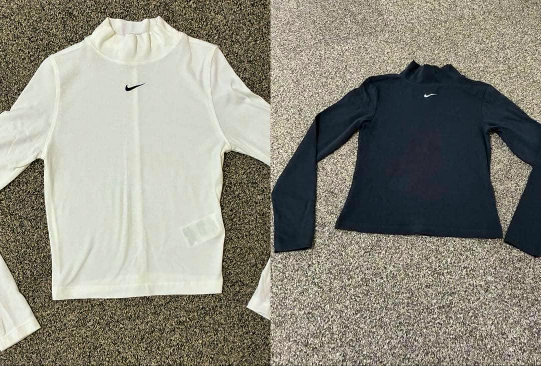 A white and a black NIKE high-neck long-sleeve top laid flat showing the front with small Swoosh logos.