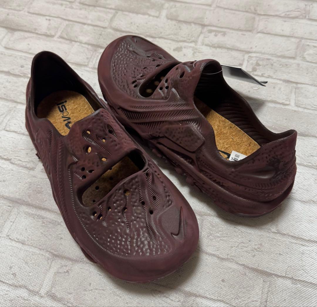 Angled top view of maroon Nike ISPA Universal rubber sandals (27.0 cm) on a fabric surface.