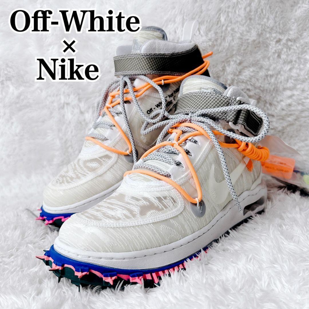 Pair of Off-White × Nike Air Force 1 sneakers with orange laces on a white fuzzy background.
