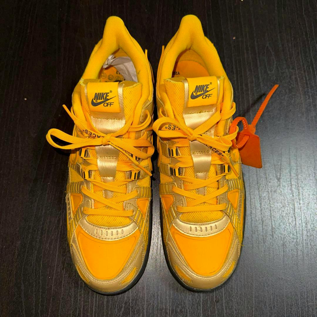 Top-down view of the yellow and gold NIKE x Off-White Rubber Dunk Gold sneakers showing tongues, laces, and the orange zip tie.