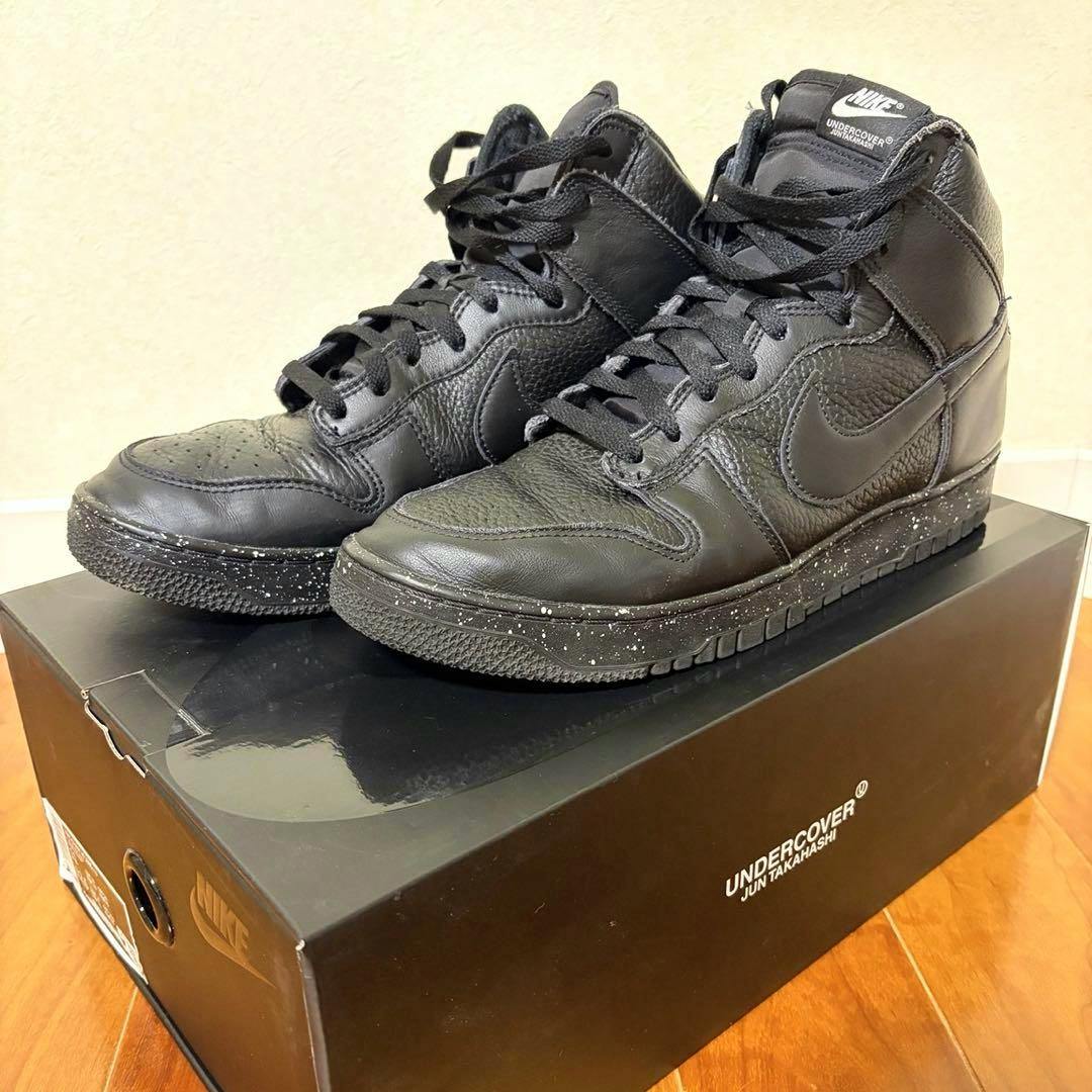 Black NIKE×UNDERCOVER DUNK sneakers displayed on top of their black box.