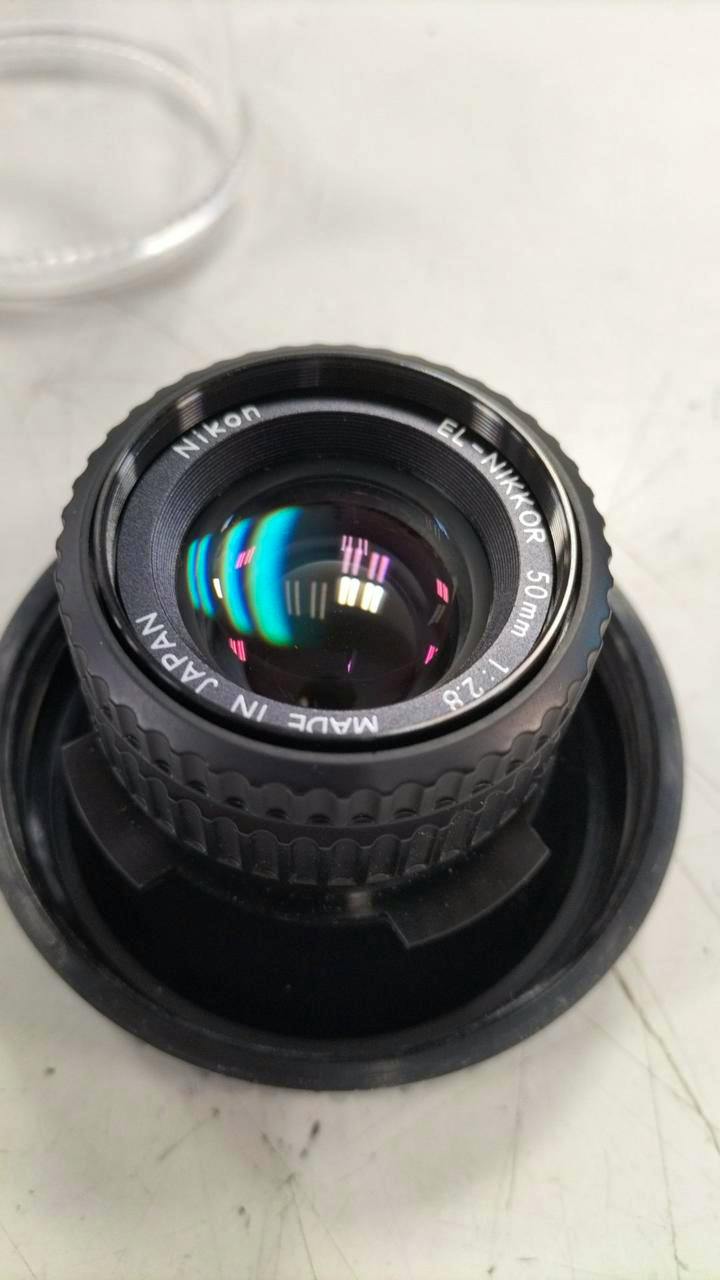 Front view of a Nikon EL-Nikkor 50mm f/2.8 prime lens showing the front element and engraved markings.
