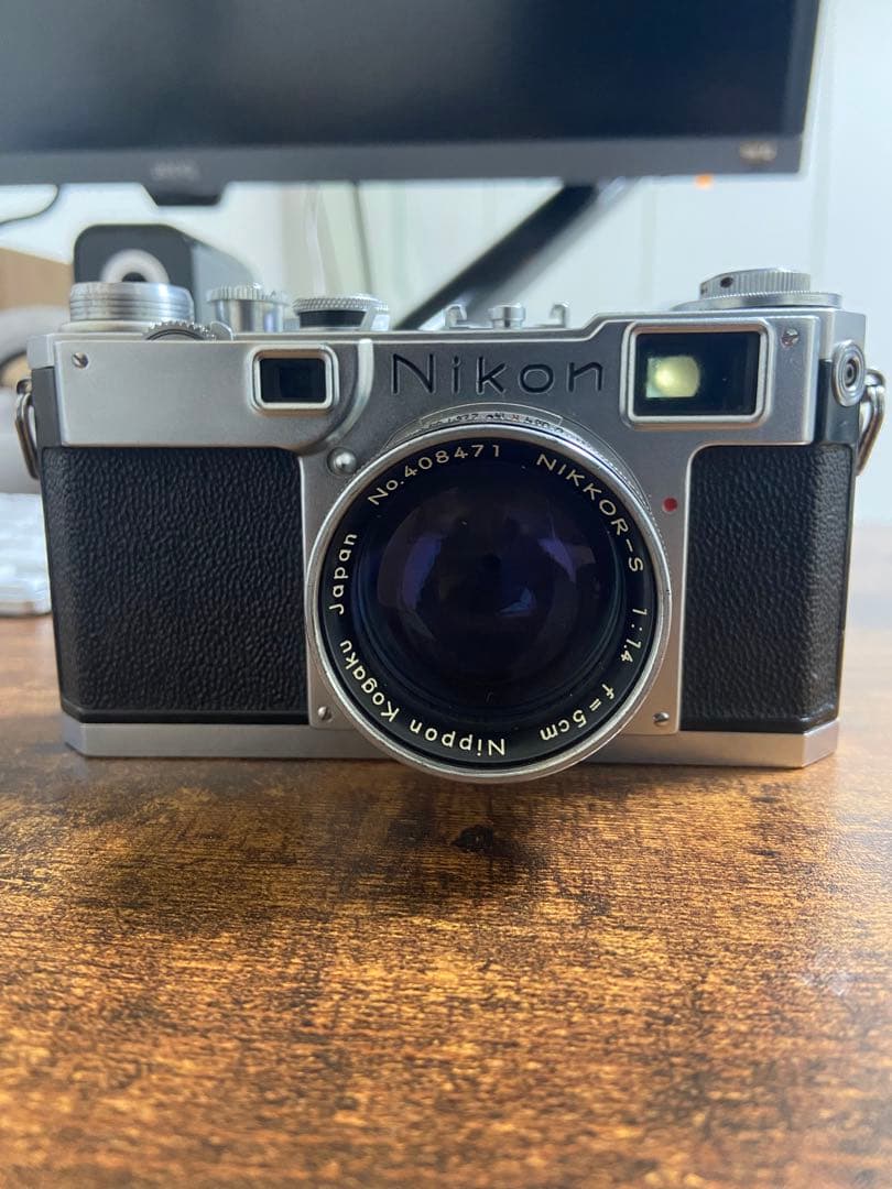 Front view of the Nikon S2 rangefinder camera with the Nikkor‑s.c 5cm f/1.4 lens mounted, sitting on a wooden surface.