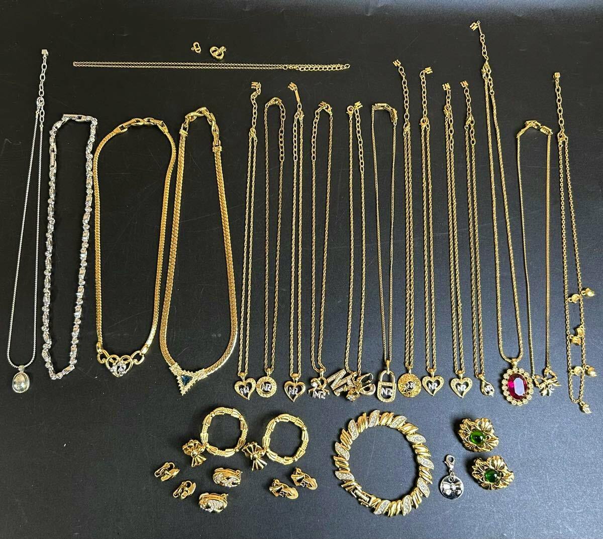 A laid-out assortment of necklaces, bracelets, earrings, and pendants on a black background.