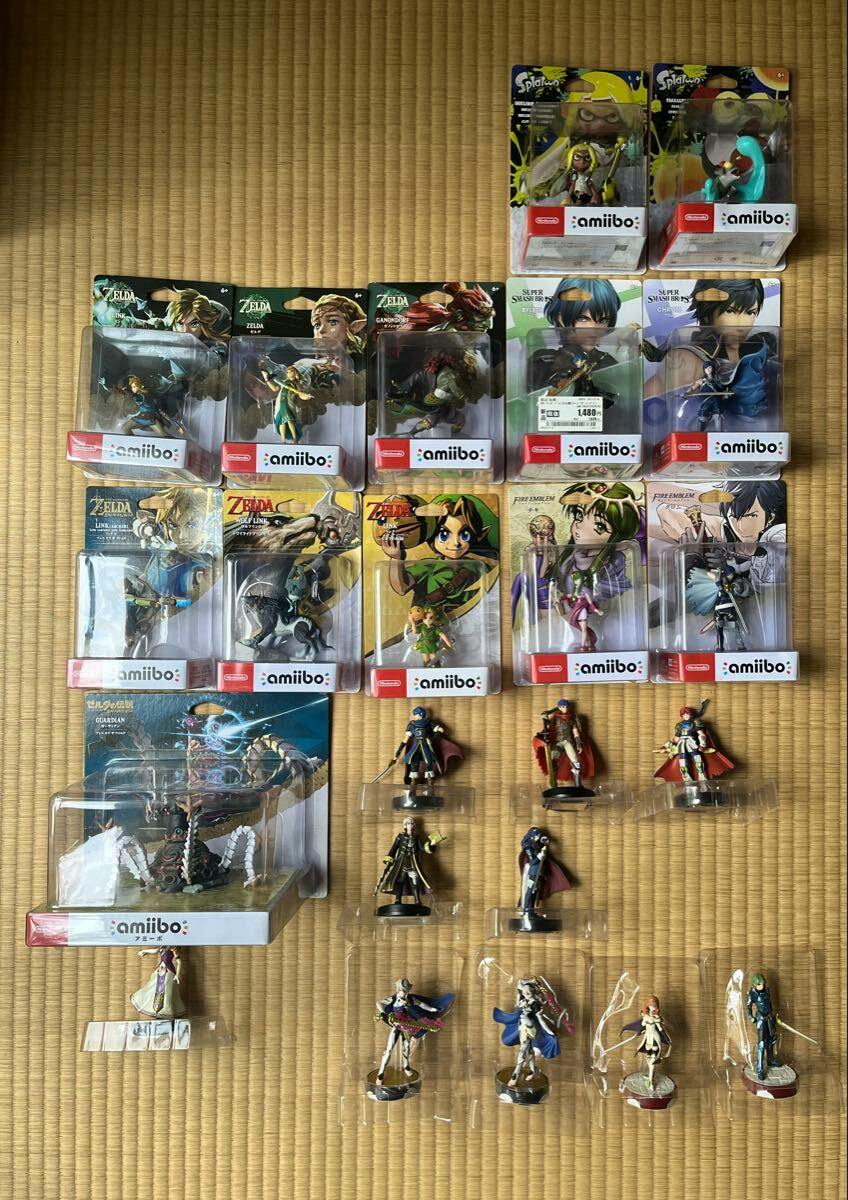 Top-down photo of amiibo figures and packaged amiibo from Zelda, Fire Emblem, and Splatoon (including Link, Celica, Guardian) arranged on a tatami mat.