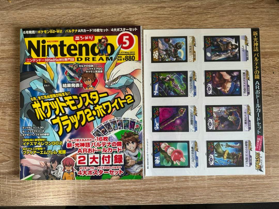 Top-down photo of the Nintendo Dream May 2012 magazine showing the cover with Pokémon Black 2/White 2 artwork and an adjacent sheet of AR-style cards.