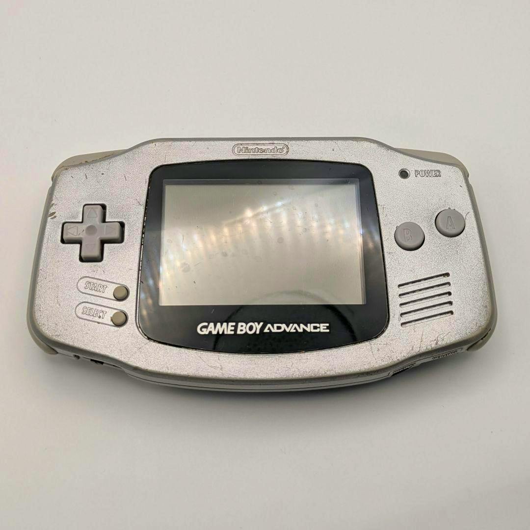 Front view of a silver Game Boy Advance (GBA-001) handheld console showing the screen, D-pad, and A/B buttons with visible wear.