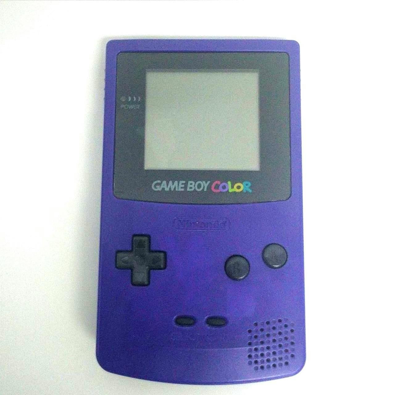 Front view of a purple Game Boy Color handheld console showing the screen, D-pad, A/B buttons, and speaker.