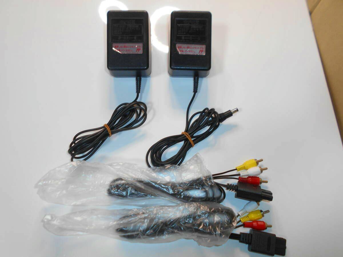 Two Super Famicom (SFC) AC adapters and multiple AV cables displayed on a white background.
