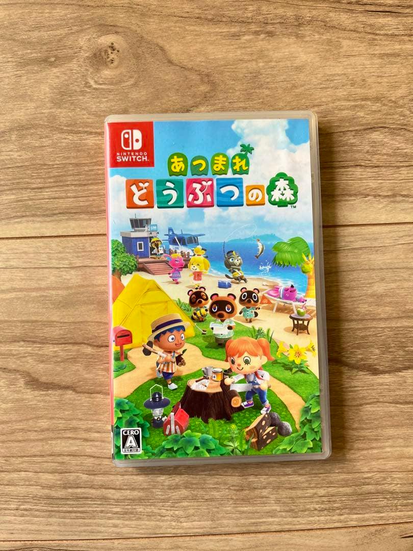 Photograph of the front of the Nintendo Switch game case for あつまれ どうぶつの森 lying on a wooden surface.