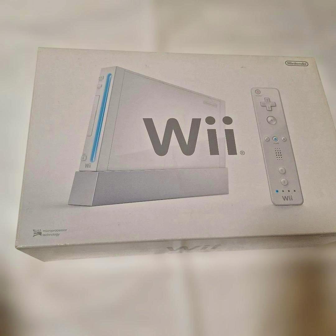 Front of a white Nintendo Wii retail box showing the Wii console illustration, a Wii Remote illustration, and a large "Wii" logo.