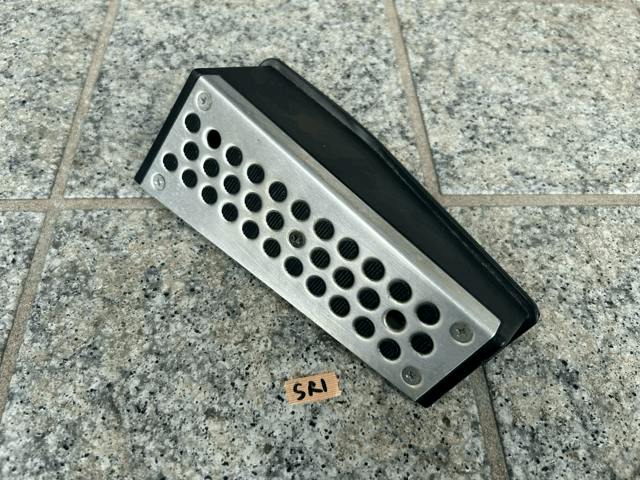 OEM footrest for Z33 Fairlady Z (VQ35) with a perforated metal face and black plastic backing placed on a tiled floor.