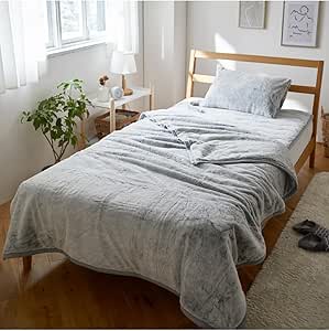 Gray Nissen Mofumofu 2-piece blanket set (blanket and pillow) displayed on a wooden bed in a bright bedroom setting.