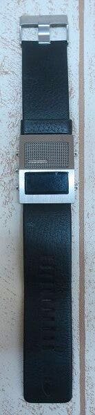 Top-down photo of the Nixon "The Dictator" wristwatch showing the black strap, rectangular metal case and metal buckle.