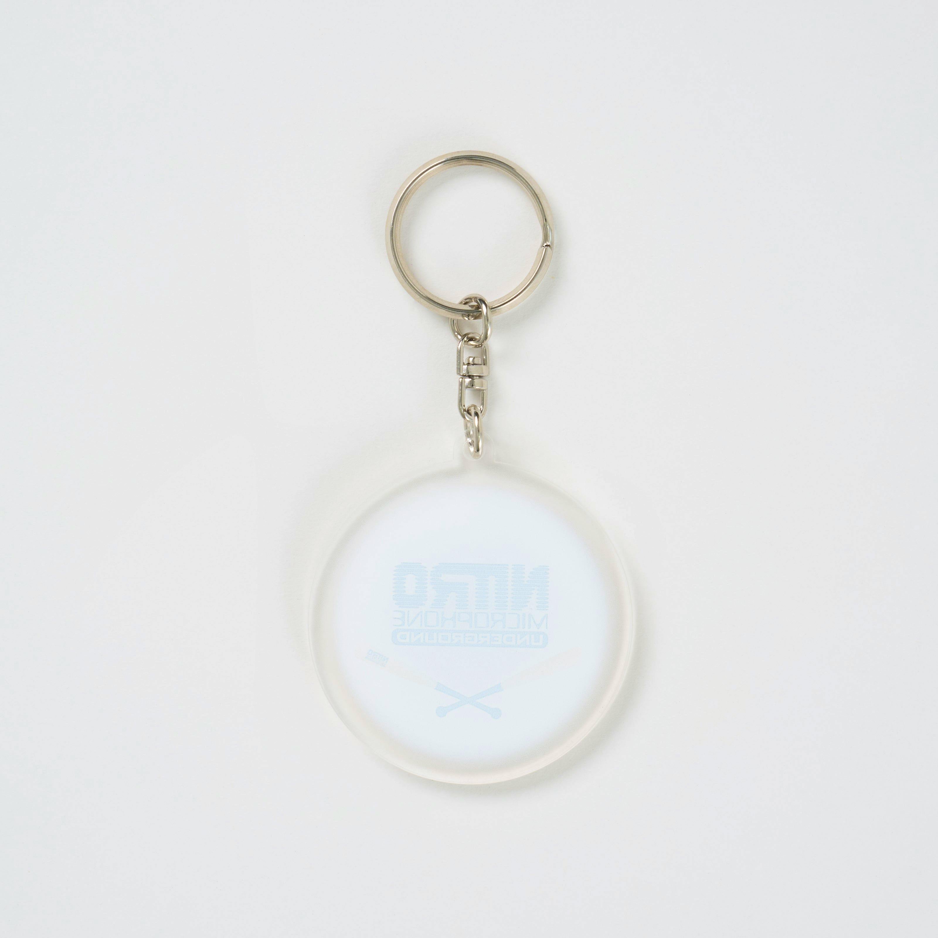 A circular NMU SHUTTA acrylic keychain showing printed "NITRO MICROPHONE UNDERGROUND" graphics attached to a silver key ring.