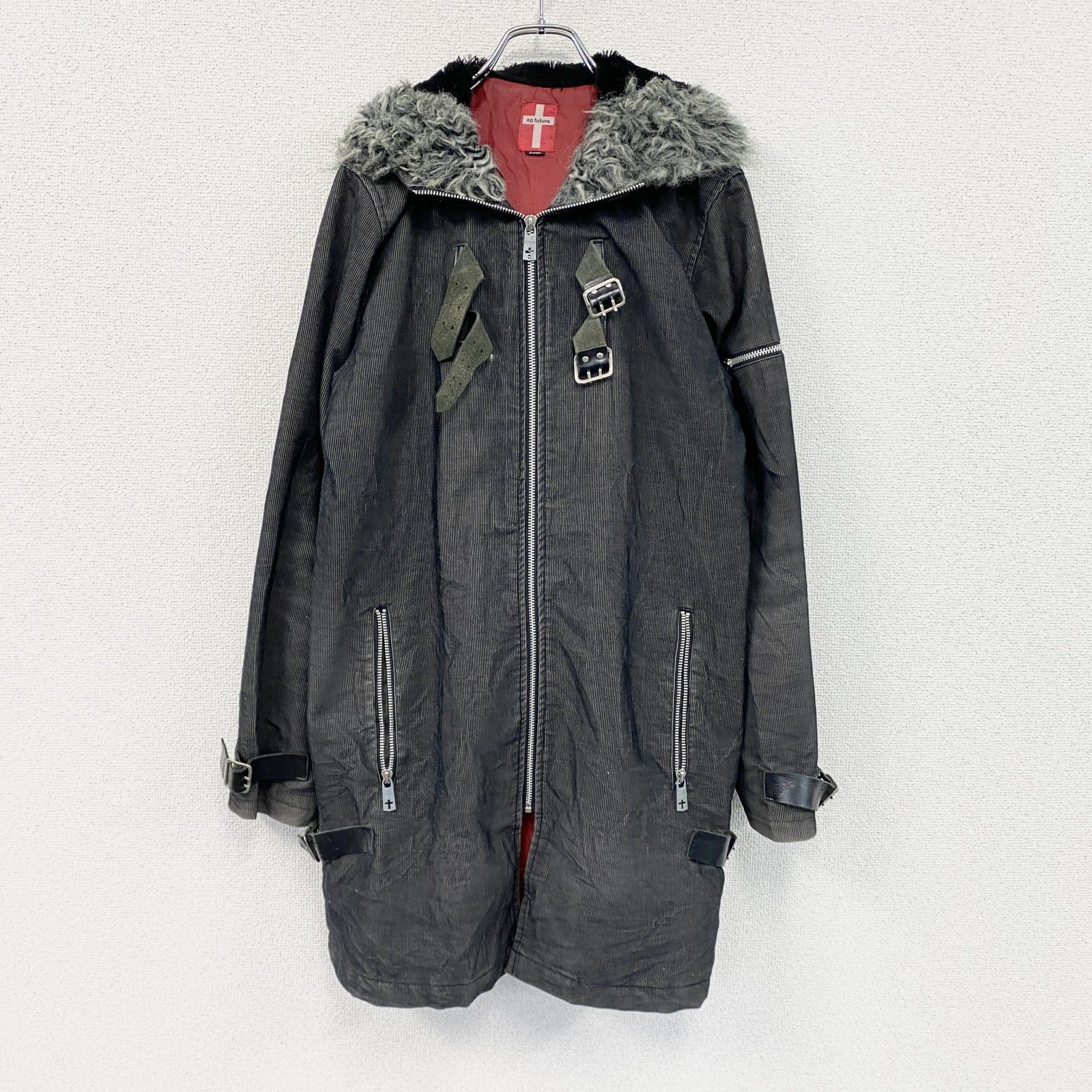 Front view of a black No Future men's cotton mods coat with fur-trimmed hood, buckles, and front zipper hanging on a hanger.