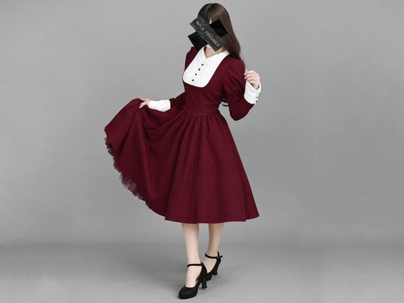 Front view of a model wearing a burgundy retro-style women's dress with a white collar and cuffs.