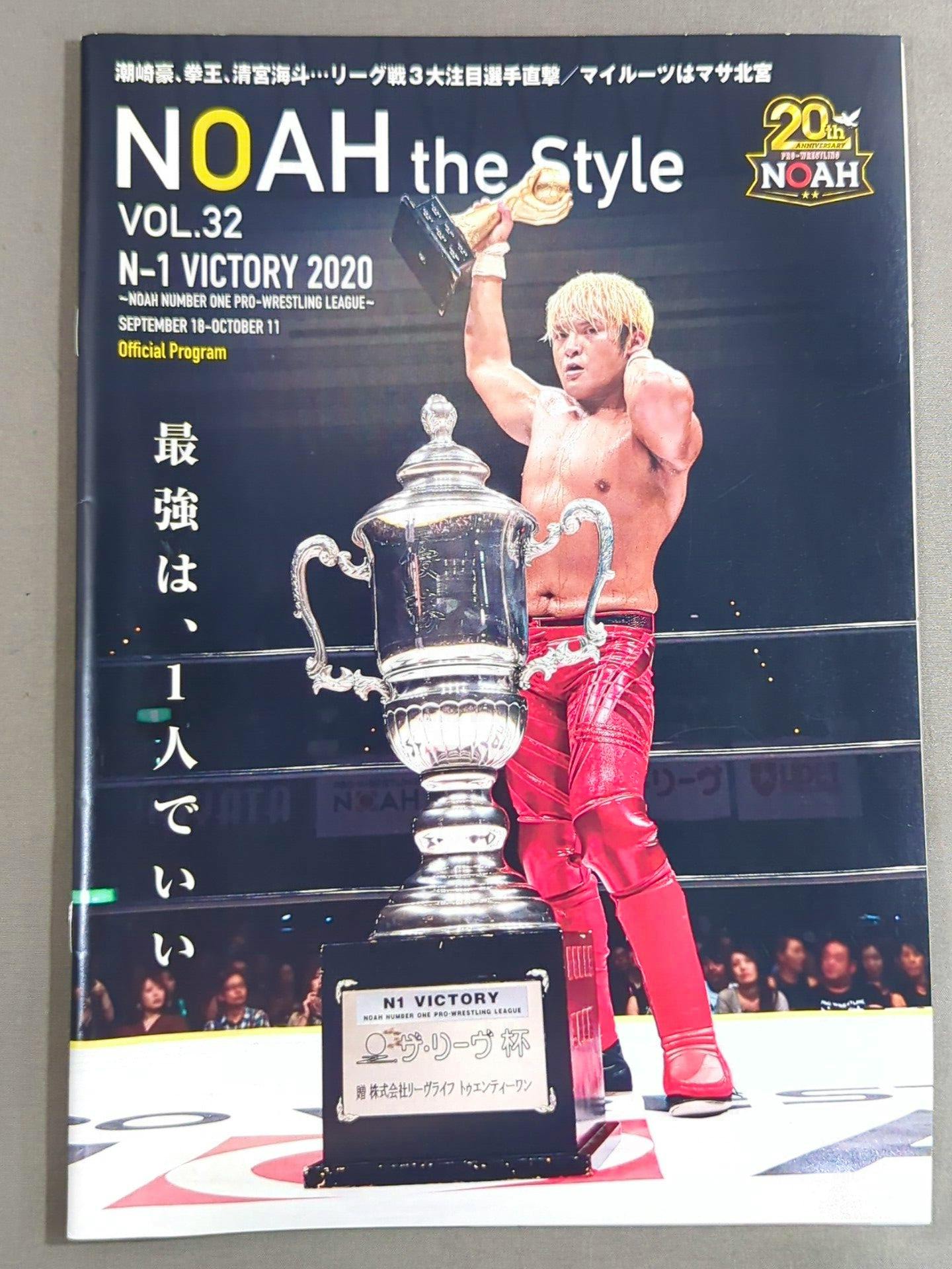 Front cover of the NOAH the Style Vol.32 magazine showing a wrestler in red pants holding a trophy with a large cup in the foreground.