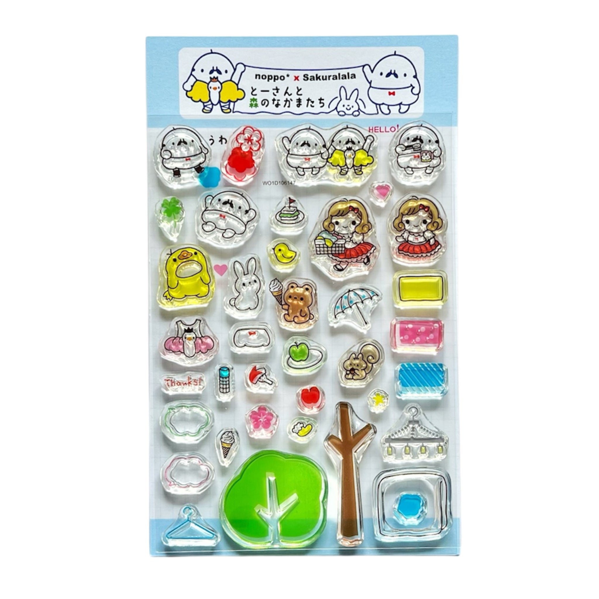 A packaged set of clear plastic stamps showing cute cartoon characters, a tree, and small icons on a blue backing.