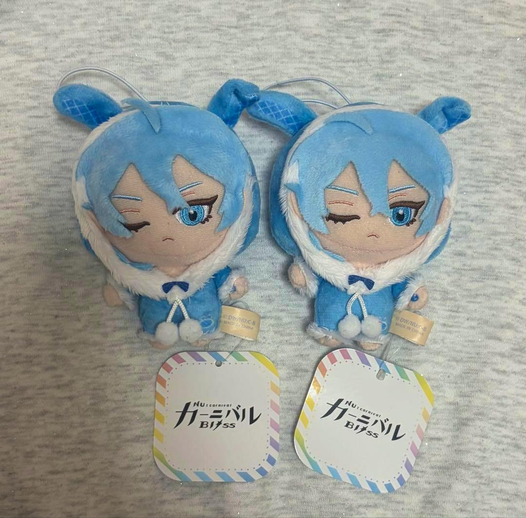 Front view of two blue mascot plush keychain toys placed side by side with their hang tags visible.
