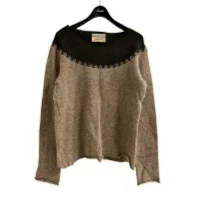 Beige and brown knit sweater by NUMBER (N)INE hanging on a hanger against a white background.
