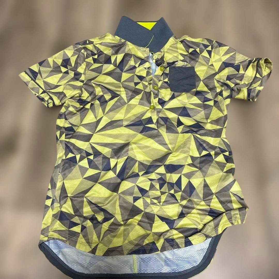 Yellow and gray geometric patterned Oakley women's golf polo shirt laid flat showing short sleeves, button placket, chest pocket, and contrast collar.