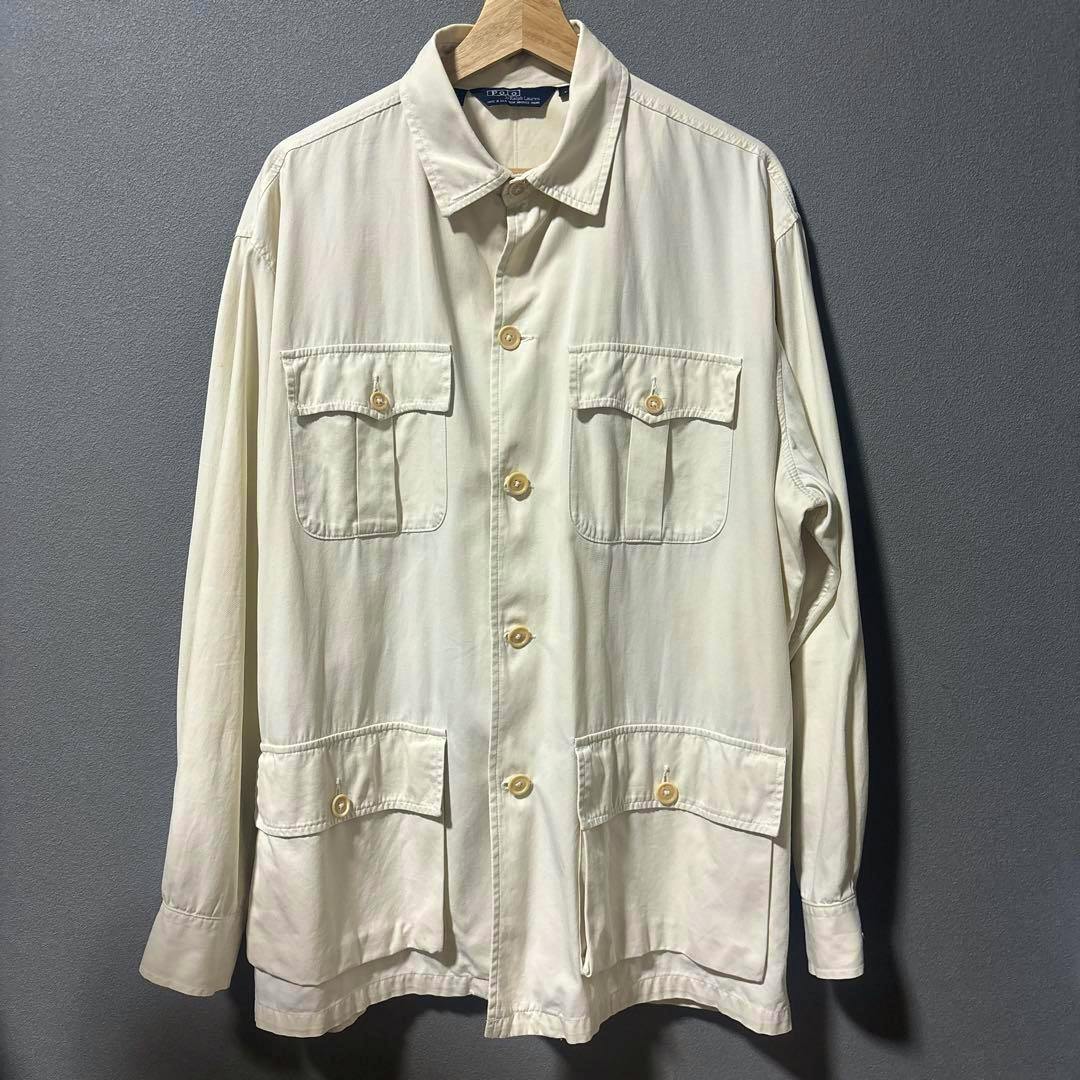 Front view of a men's cotton jacket hanging on a wooden hanger against a gray wall.
