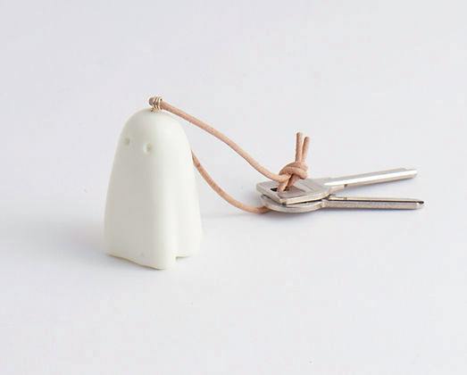White ghost-shaped Obake key chain on a leather strap attached to two metal keys on a white background.