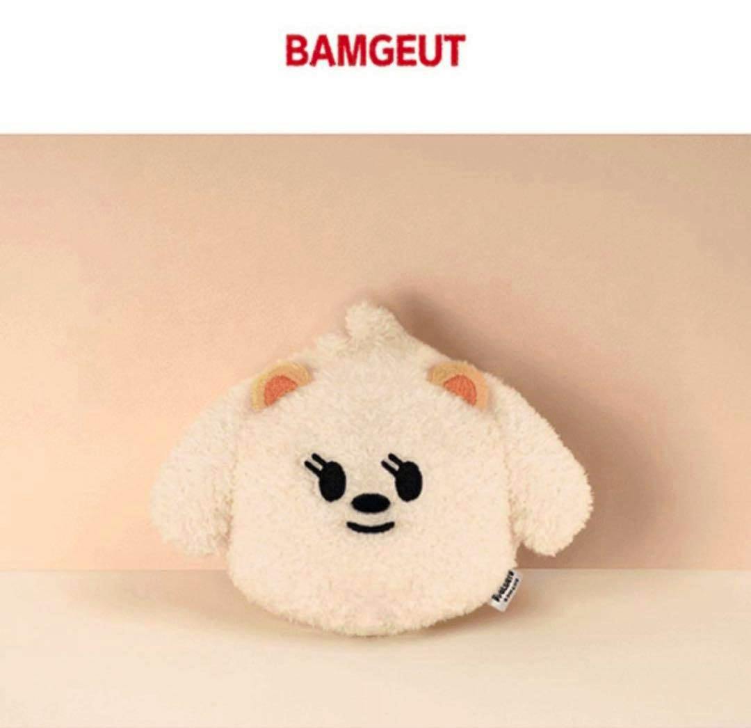 Cream-colored round plush toy with an embroidered face and small ears on a beige background.