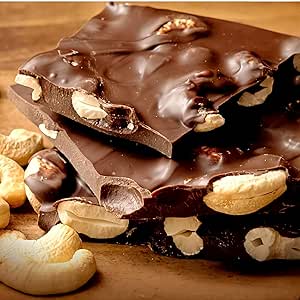 Close-up photo of chocolate pieces studded with cashew nuts.