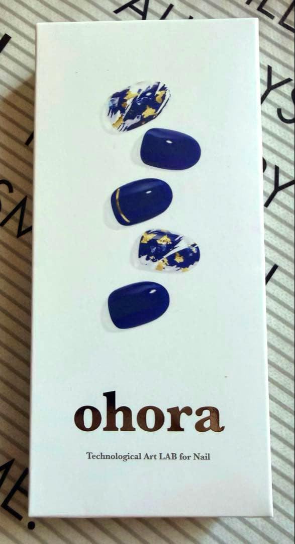 Photo of the ohora nail sticker packaging showing five blue-and-gold sample nail sticker designs on a white box with the ohora logo.