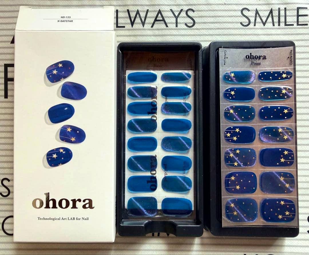 Main image shows the ohora N Daystar nail sticker packaging and two trays of blue, star-patterned nail stickers.