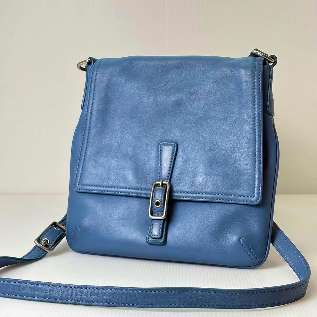 Front view of a light blue Old Coach leather crossbody shoulder bag with a flap and buckle closure.