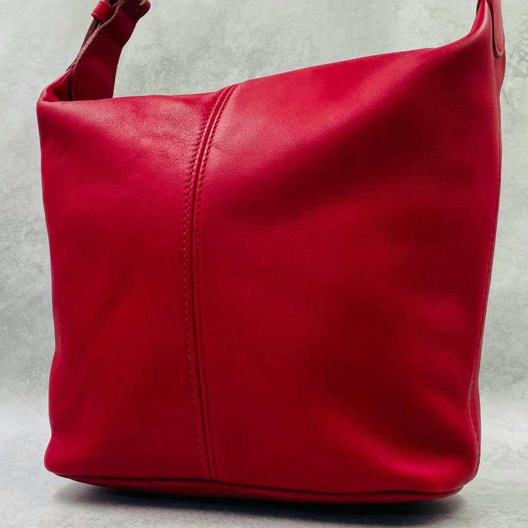 Front view of a red leather one-shoulder bag on a neutral background.