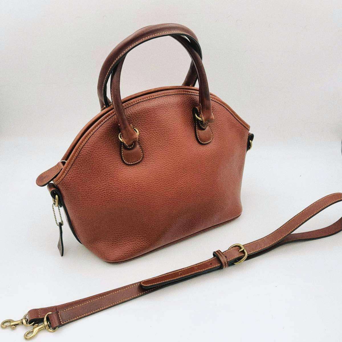 Brown grained leather 2-way handbag with top handles and a detached shoulder strap displayed on a white background.