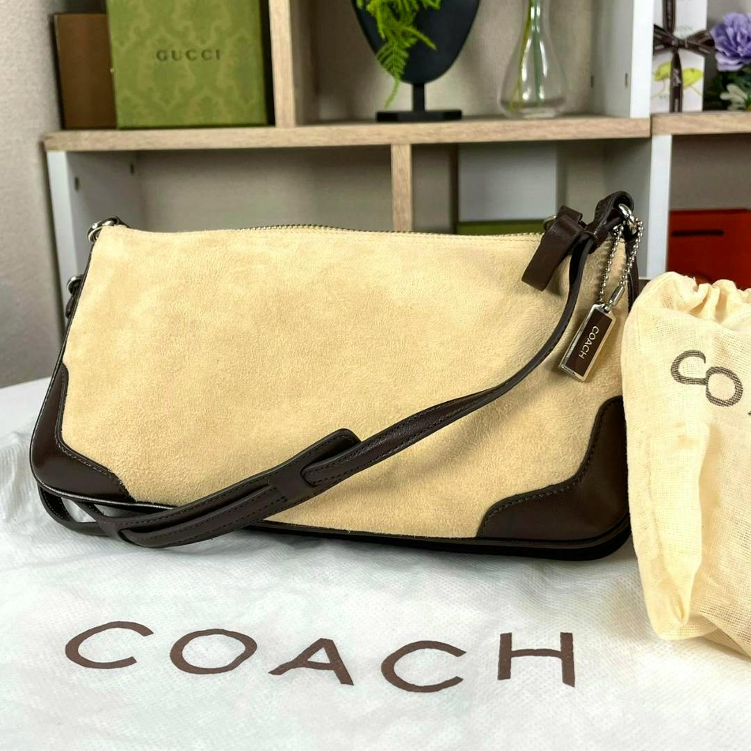 Beige suede and dark brown leather OLD COACH one-shoulder bag on a COACH dust bag with metal tag.