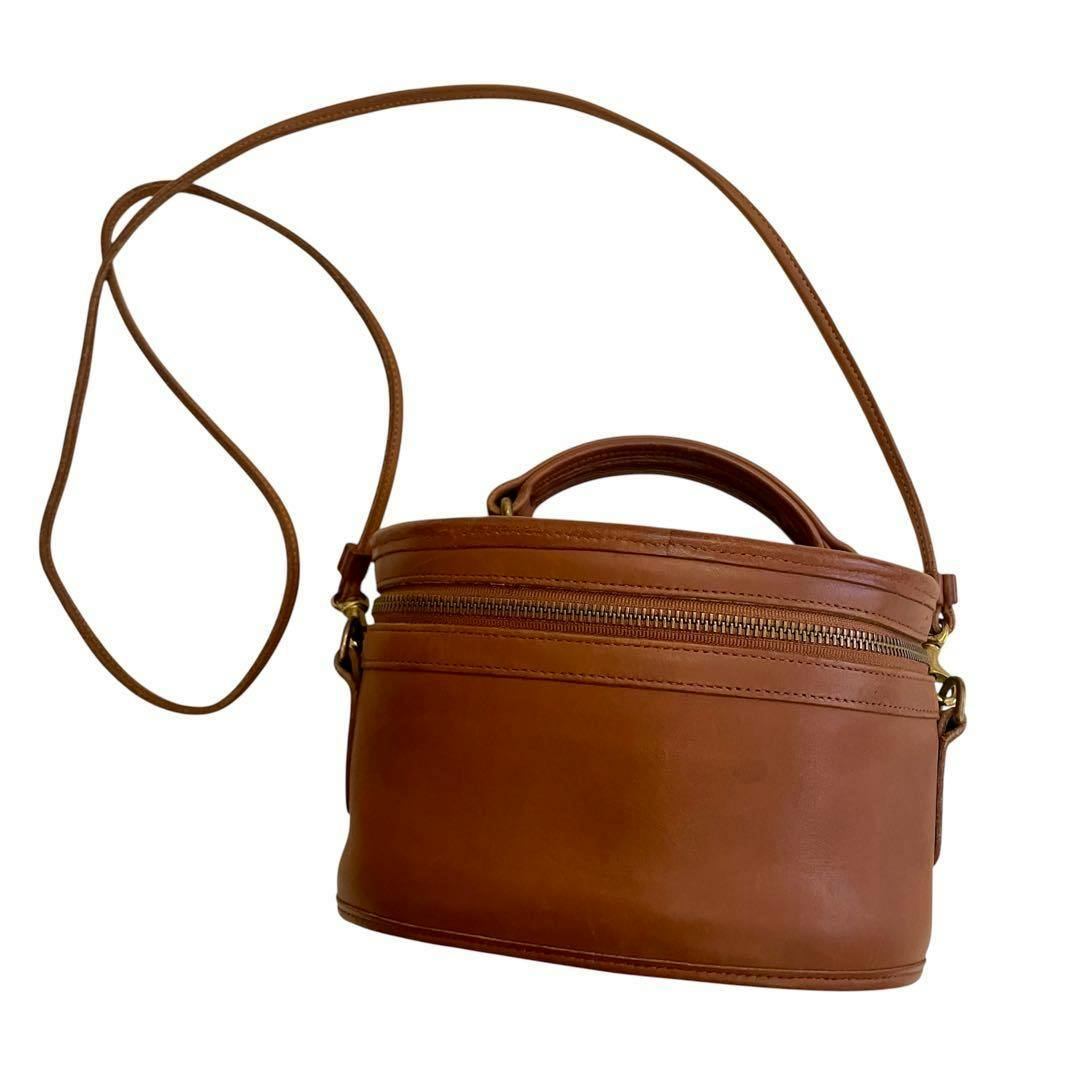 Brown cow leather vintage COACH 2-way vanity shoulder bag with top handle and long shoulder strap on a white background.