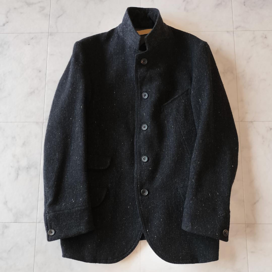 Black OLD JOE British tweed men's sack jacket laid flat showing the front with button closure and stand collar.