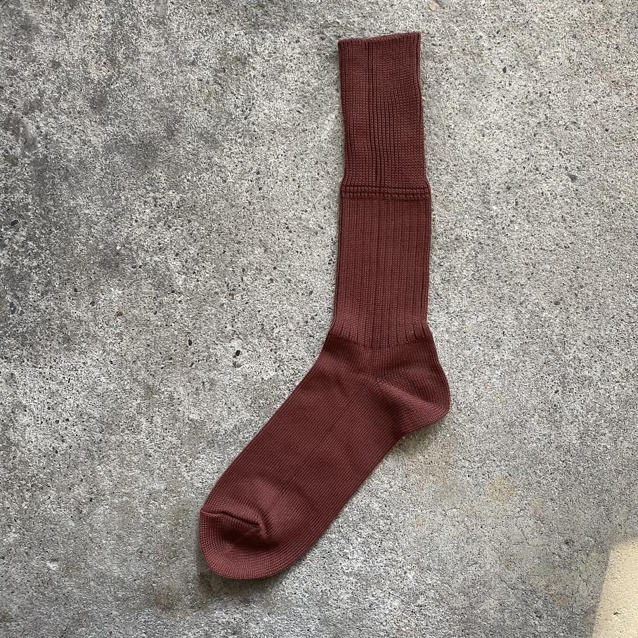 Olde Homesteader heavy weight "Plain Rib" mahogany sock laid flat on a concrete surface.