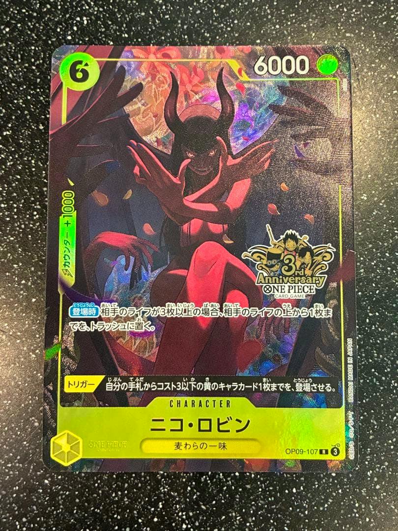 Front of the ONE PIECE trading card ニコ・ロビン showing the character artwork, 6000 value, and 3rd Anniversary logo on a black speckled background.