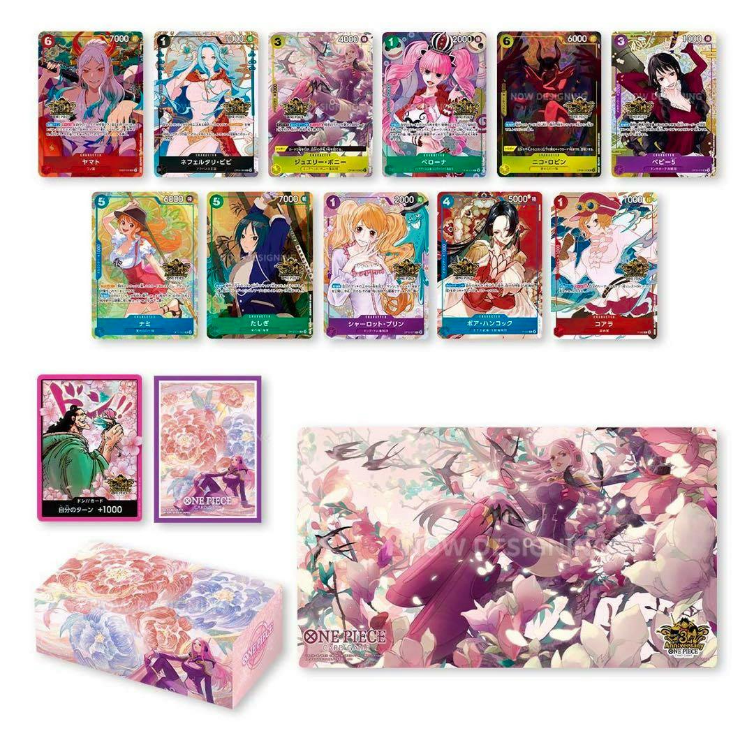Multiple ONE PIECE trading cards displayed with matching card box and playmat artwork for the 3rd Anniversary set.