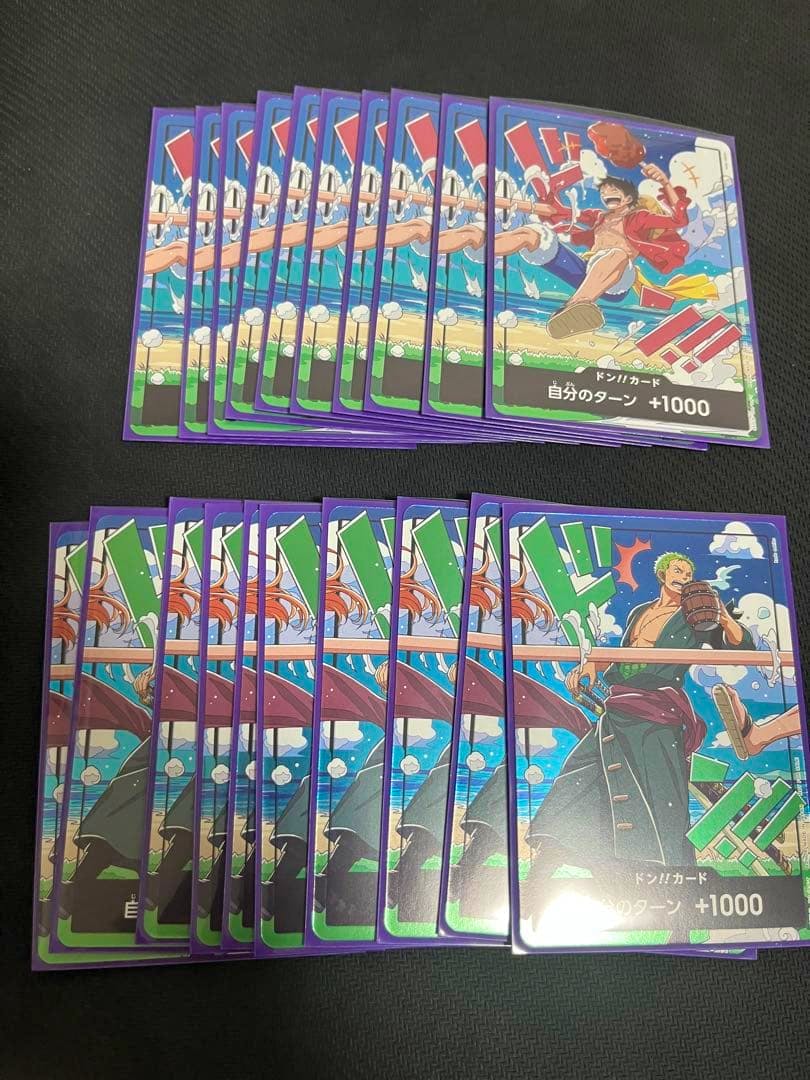 Twenty One Piece trading cards (Luffy and Zoro promo cards) arranged in two fanned rows on a dark surface.