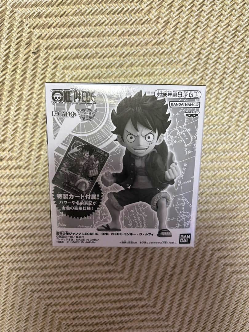 Photo of the boxed LECAFIG One Piece Luffy figure showing the front of the product box with an image of Luffy and a promotional card.