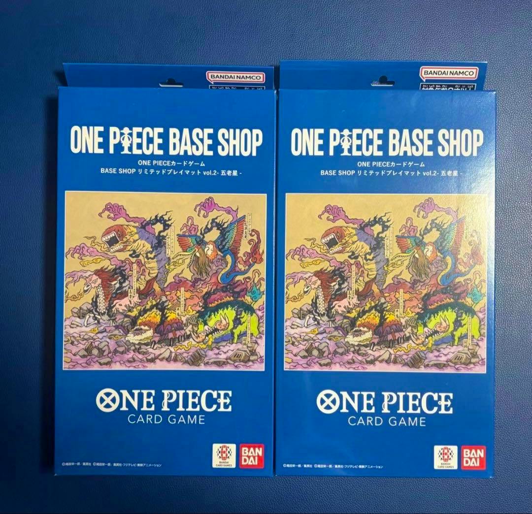 Two boxed One Piece Base Shop playmats (vol.2) in blue packaging shown side by side with artwork and Bandai logo.